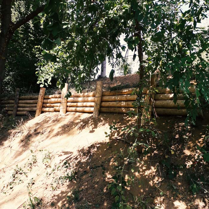consolidamento terreno in pendenza in area boschiva con pali di castagno